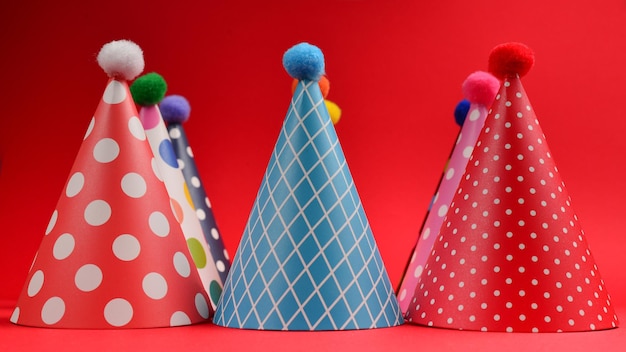 Gorras de cumpleaños coloridas sobre un fondo rojo