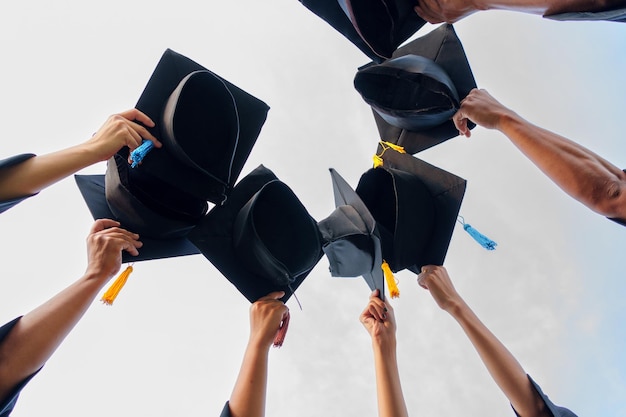 Gorras de graduación lanzadas al aire graduados exitosos de la universidad Concepto educación felicitación graduados en la Universidad