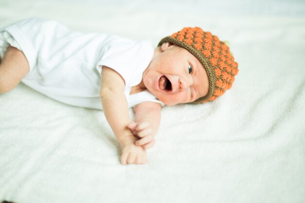 Gorro de bebê recém-nascido fofo deitado na cama.