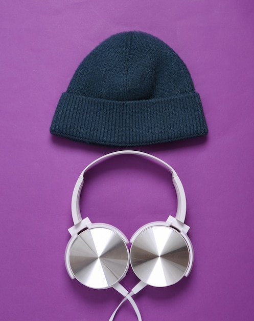 Gorro e fones de ouvido estéreo em um fundo roxo Conceito de música de festa juvenil