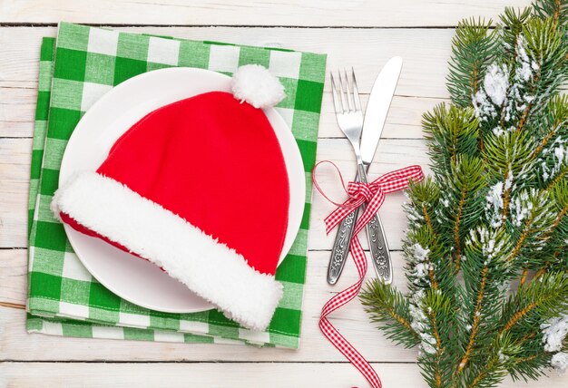 Foto gorro de papá noel en platería y árbol de navidad