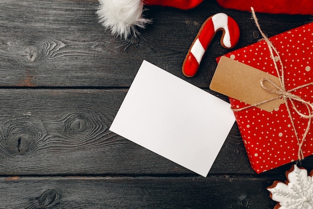 Gorro de Papá Noel y regalo de Navidad sobre fondo de madera