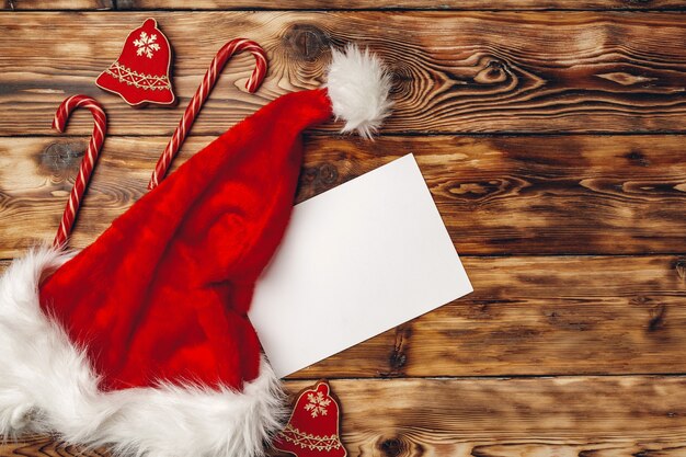 Gorro de Papá Noel y regalo de Navidad en la vista superior de fondo de madera