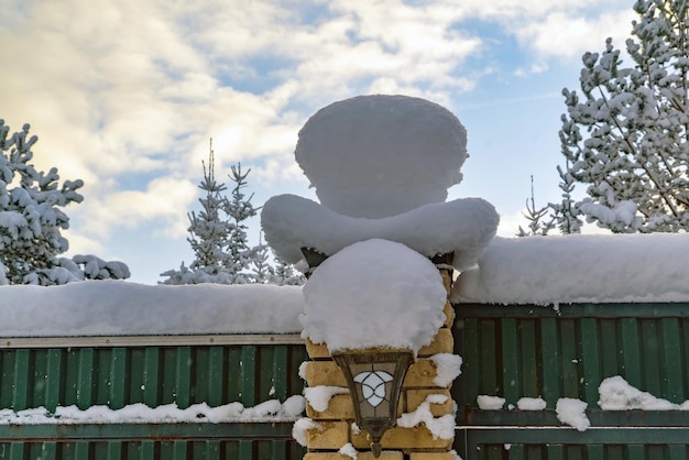 Gorros de nieve en un pilar en la puerta de la casa