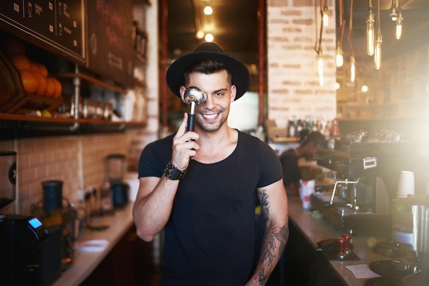 Gostamos de manter a diversão por aqui Foto de um jovem cobrindo o olho com um filtro de café enquanto trabalhava em um café