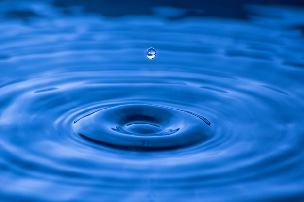 Gota de agua cerca de en un fondo azul borroso