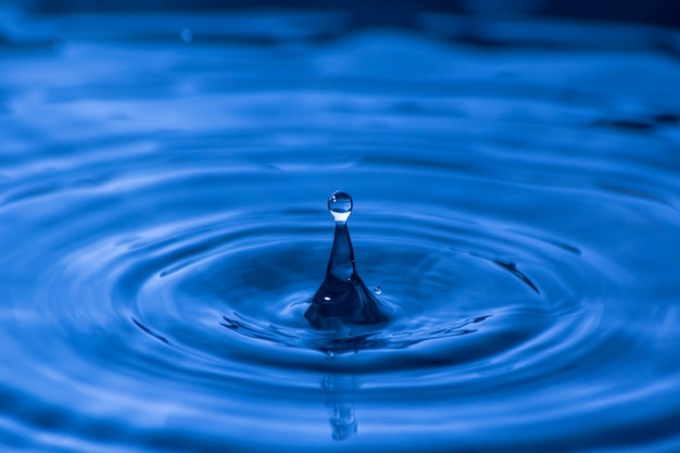 Gota de agua cerca de en un fondo azul borroso