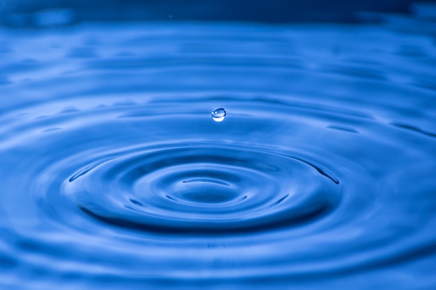 Gota de agua cerca de en un fondo azul borroso