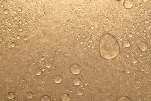 Gota d'água em fundo de textura de parede de cor dourada