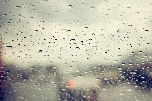 Foto gota de chuva abstrata no escudo do carro da frente da janela no filtro retrô