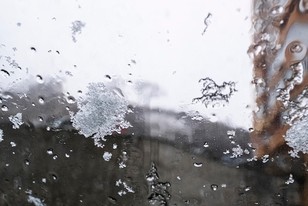 Gota de chuva de água de chuva em vidro com fundo ao ar livre