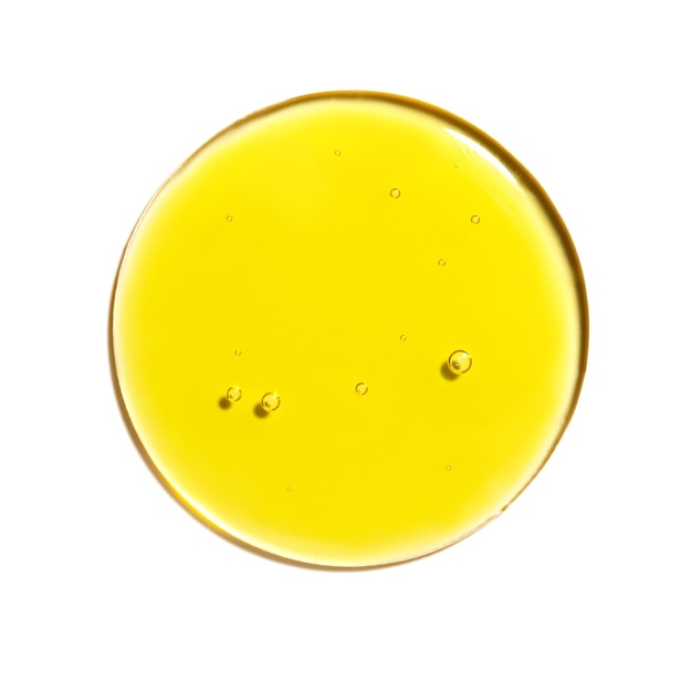 Gota de textura de muestra de aceite amarillo en placa de petri con cosméticos de burbujas aislado sobre fondo blanco