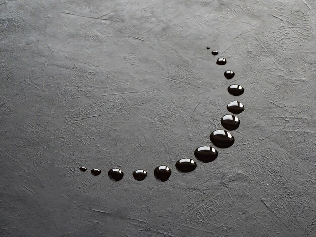 Las gotas de aceite en forma de luna creciente sobre un fondo negro.