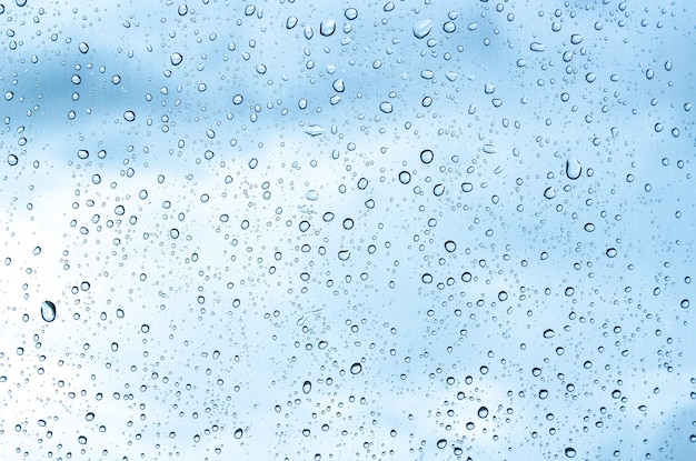 Gotas de agua azul sobre fondo de gota de vidrio o lluvia