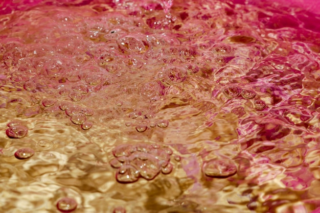 Las gotas de agua caen en la superficie del agua que causa una ondulación.