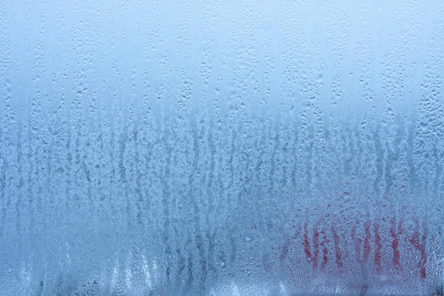 Gotas de agua de fondo en el vidrio de la ventana húmeda con salpicaduras y gotas de agua y textura de cal fondo de otoño Condensación en el vidrio