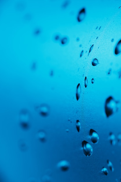 Gotas de agua limpia en el vaso. Azul