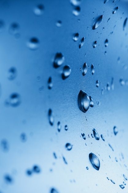 Gotas de agua limpia en el vaso. Azul