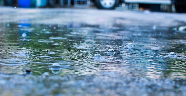 Gotas de agua de lluvia y en el camino abstracto desenfoque de fondo