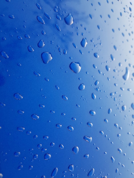 Gotas de agua de lluvia sobre fondo de metal azul