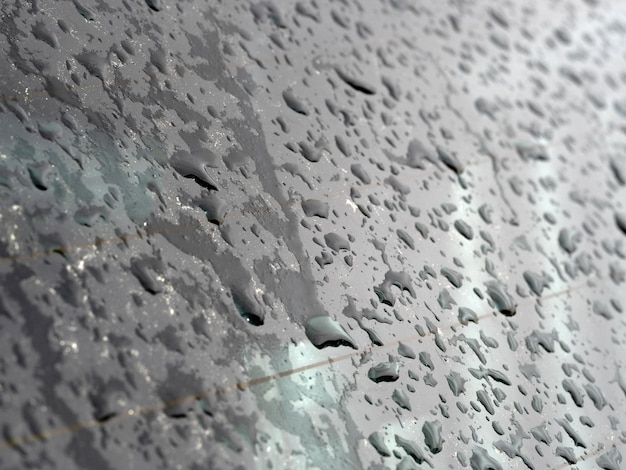 Las gotas de agua de lluvia en la ventana del vidrio del coche