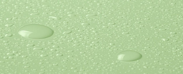 Gotas de agua micelar o tónico cosmético sobre un fondo verde Fotografía macro de primer plano