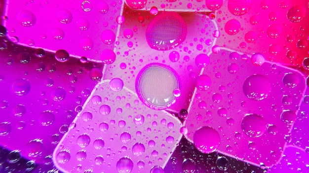 Gotas de agua en la pantalla del teléfono con un fondo colorido