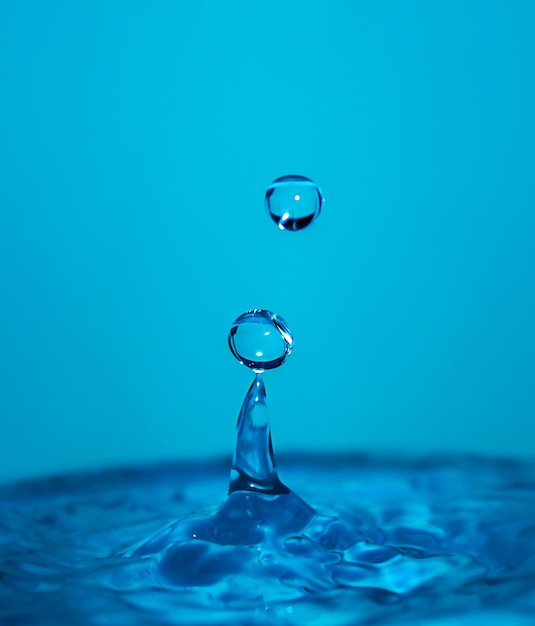 Gotas de agua que caen sobre un fondo azul Salpicaduras de agua