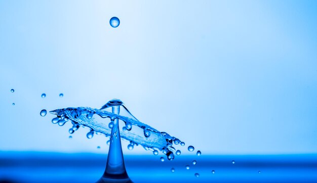 Gotas de agua salpicando en la superficie del agua azul