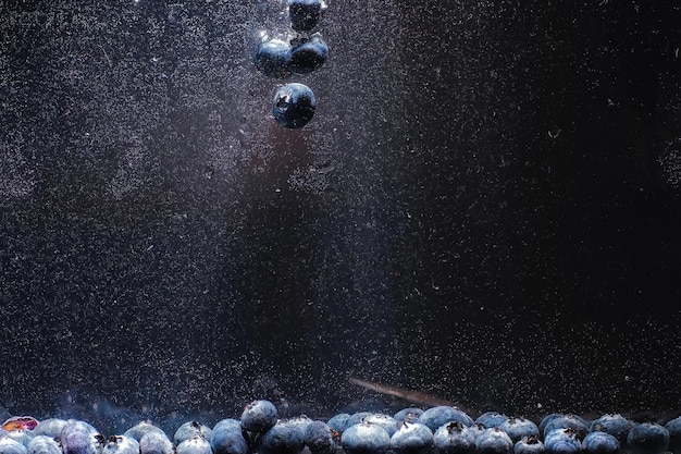 Gotas de agua sobre arándanos dulces maduros. Fondo de arándanos frescos con espacio de copia para su texto. Concepto vegano y vegetariano. Textura macro de bayas de arándanos.