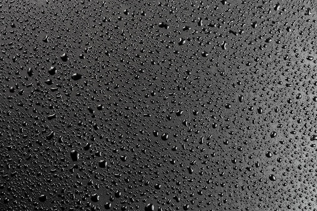 Gotas de agua sobre fondo macro de superficie hidrofóbica negra plana abstracta