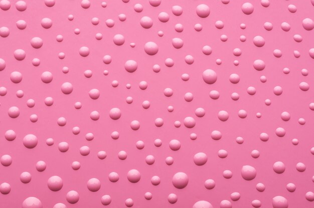 Gotas de agua sobre un fondo rosa