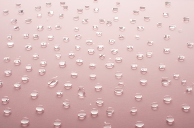 Gotas de agua sobre fondo rosa