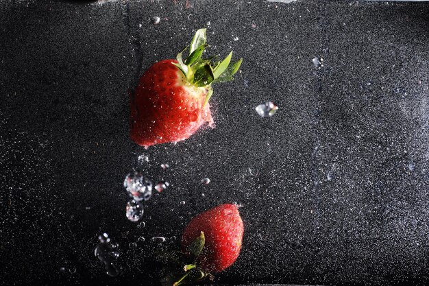 Gotas de agua sobre fresa dulce madura. Fondo de bayas frescas con espacio de copia de su texto. Concepto de comida vegana.