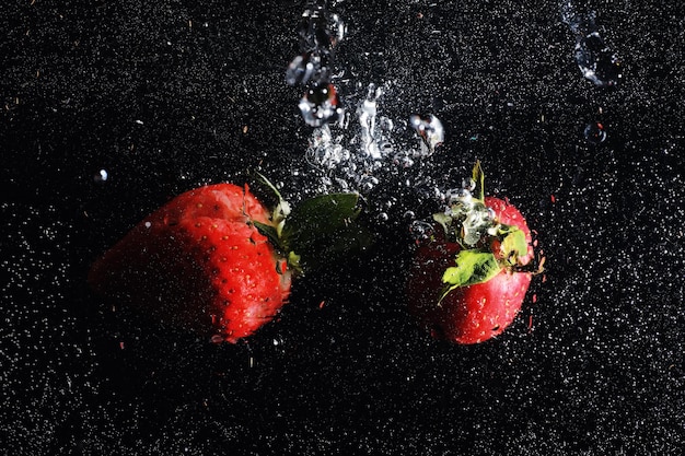 Gotas de agua sobre fresa dulce madura. Fondo de bayas frescas con espacio de copia de su texto. Concepto de comida vegana.