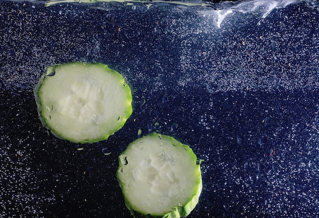 Gotas de agua sobre pepino maduro. Fondo de verduras frescas con espacio de copia de su texto. Concepto vegano y vegetariano.