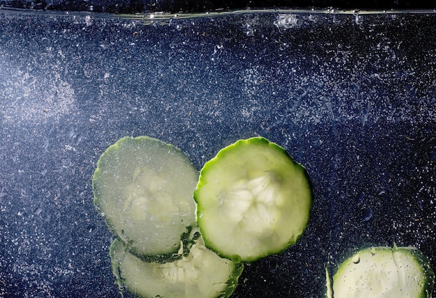 Gotas de agua sobre pepino maduro. Fondo de verduras frescas con espacio de copia de su texto. Concepto vegano y vegetariano.