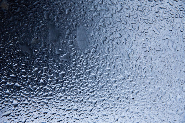 Foto gotas de agua sobre una superficie de vidrio azul oscuro