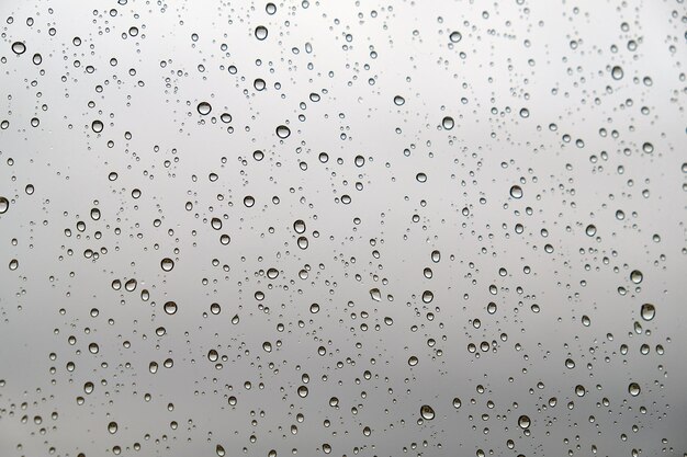 Foto gotas de agua sobre vidrio y vista de las gotas de paisaje sobre vidrio de primer plano