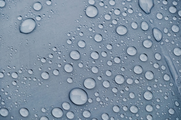 Gotas de agua textura de fondo. Gota de lluvia del primer en el paraguas. Día lluvioso