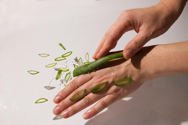 Las gotas de aloe caen y hidratan la piel de las manos femeninas.