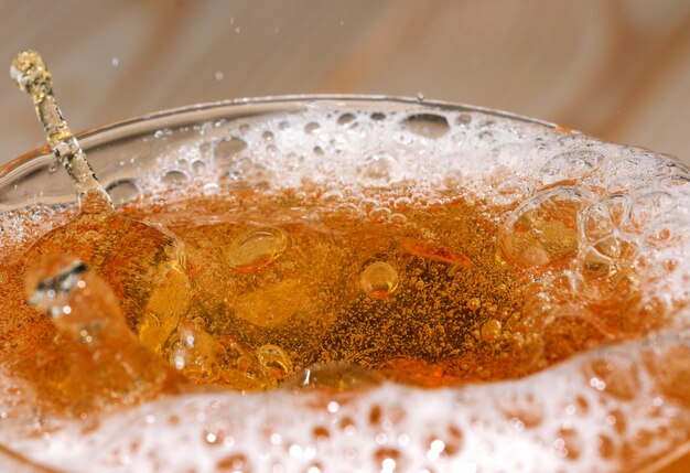 Gotas y burbujas de cerveza ligera en un disparo de bala de vidrio fotografía macro de primer plano