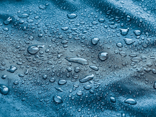 Gotas de água da chuva em tecido impermeável.