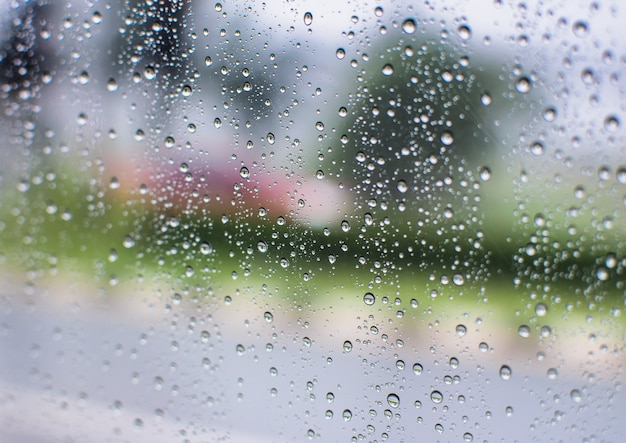 Gotas de água de chuva e texto na janela com resumo desfocagem o fundo