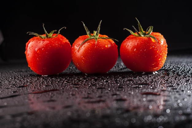 Gotas de água de tomate em fundo preto Tomates frescos pode ser usado como plano de fundo