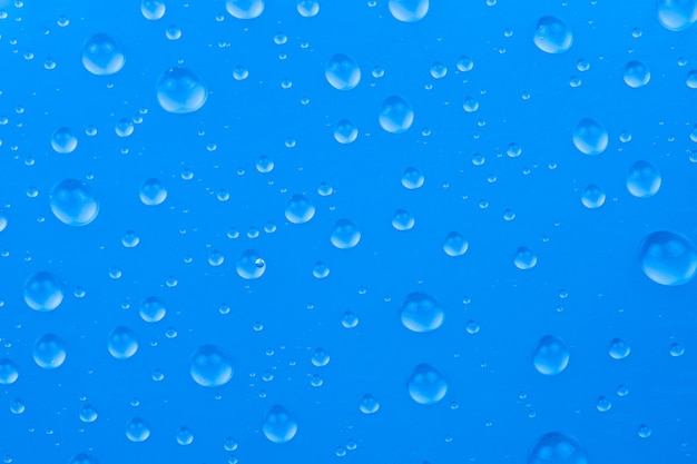 Gotas de água na superfície de vidro azul