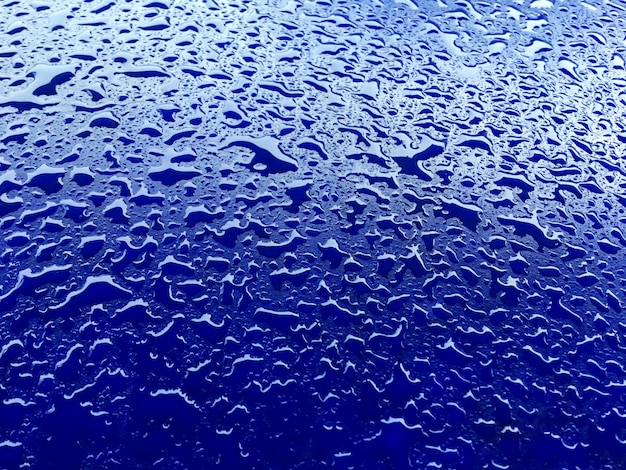 Gotas de água no fundo da superfície plástica azul