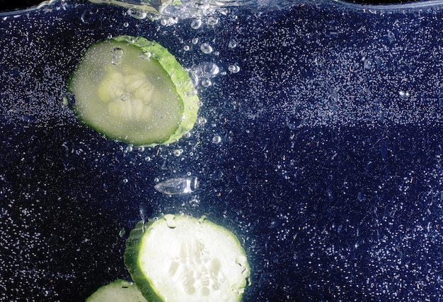 Gotas de água no pepino maduro. Fundo de legumes frescos com espaço de cópia para o seu texto. Conceito vegano e vegetariano.