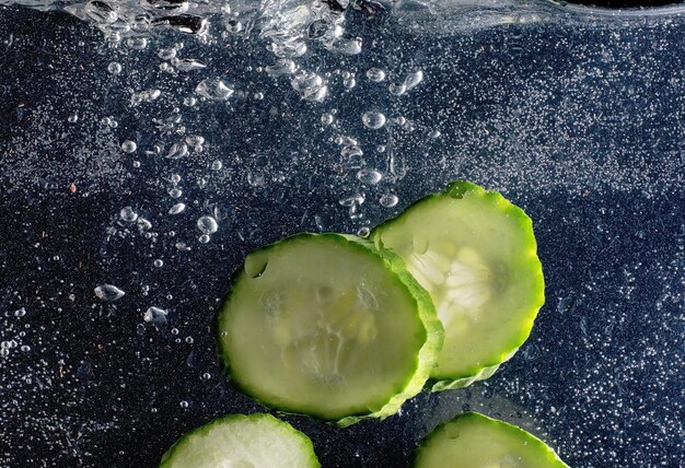 Gotas de água no pepino maduro. Fundo de legumes frescos com espaço de cópia para o seu texto. Conceito vegano e vegetariano.