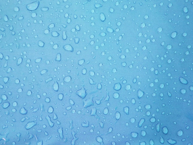 Gotas de água no tecido impermeável azul